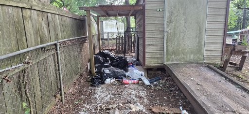 Backyard debris and trash before removal in Columbus GA — wood scraps and bags of junk