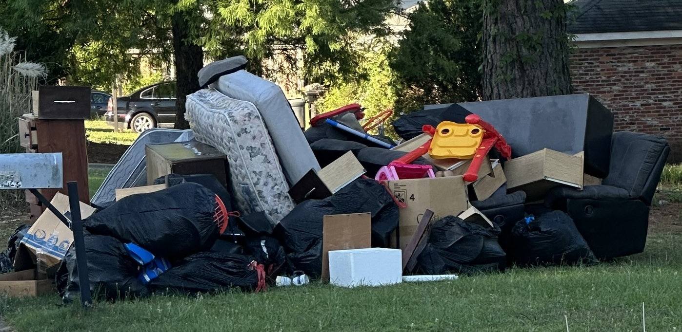 Large curbside junk pile in Columbus GA — furniture, bags, and bulk items ready for pickup