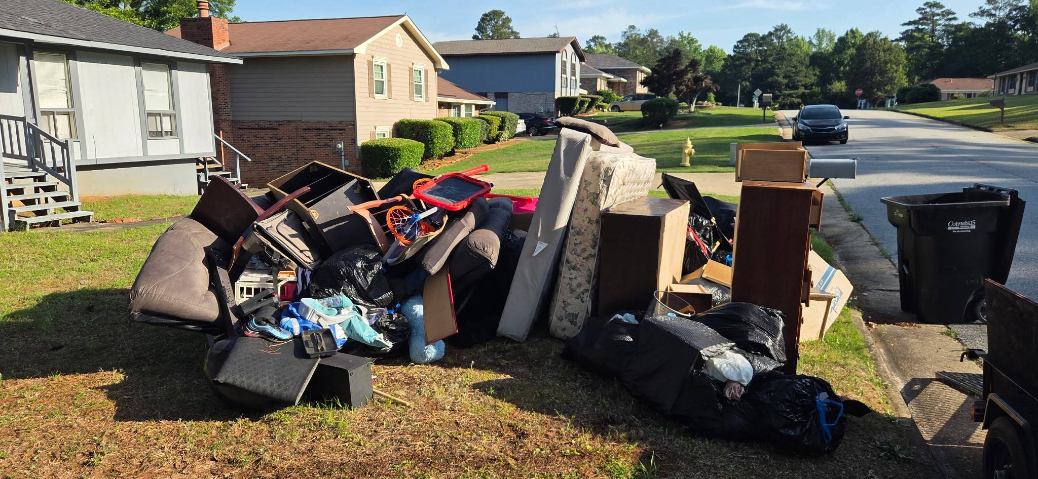Curbside bulk junk haul-off in Muscogee County GA — sofa, furniture, and boxes at curb
