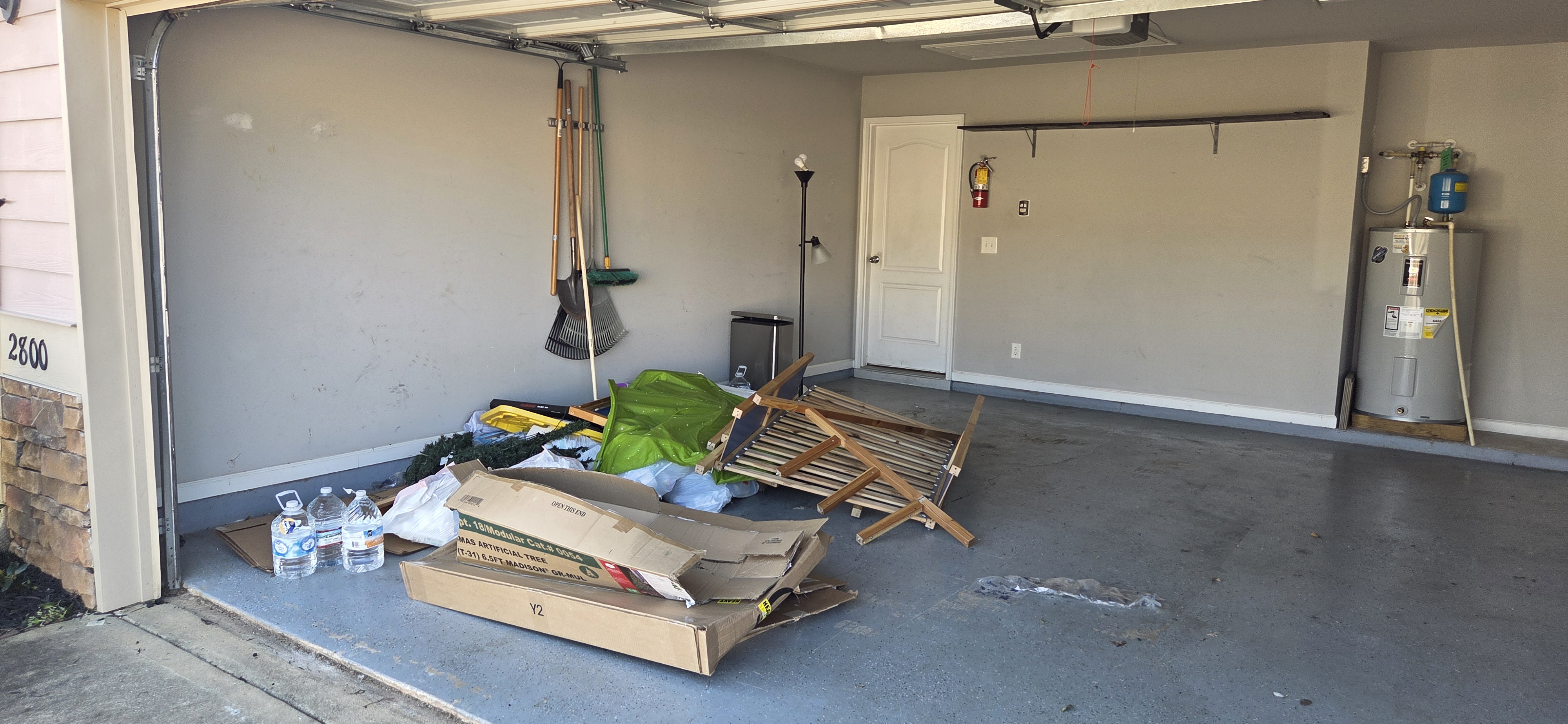Garage cleanout before — junk and cardboard piled in garage near Fort Benning Columbus GA