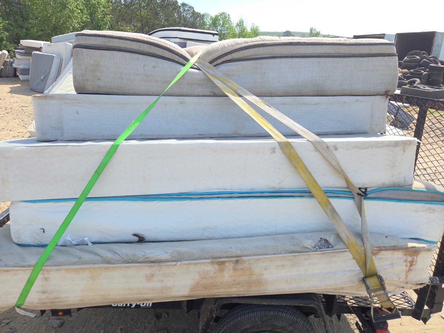 Multiple mattresses strapped to a junk removal trailer in Columbus GA — mattress haul-off service